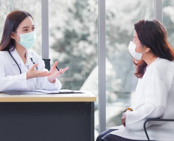 Asian elder female consults with professional doctor about her symptom or health problem in examination room at hospital.